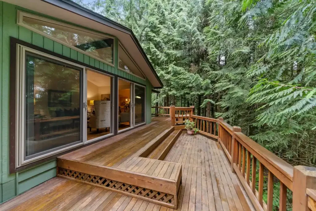 A clean brown wooden deck outside a glass patio door after deck cleaning