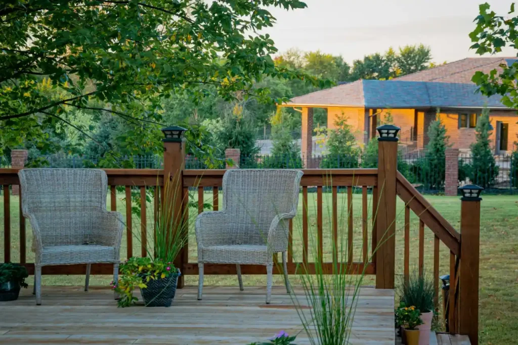 A clean wooden privacy fence beside green trees after fence cleaning
