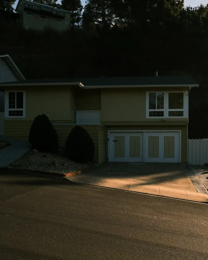 A suburban house with an attached garage and freshly cleaned concrete driveway