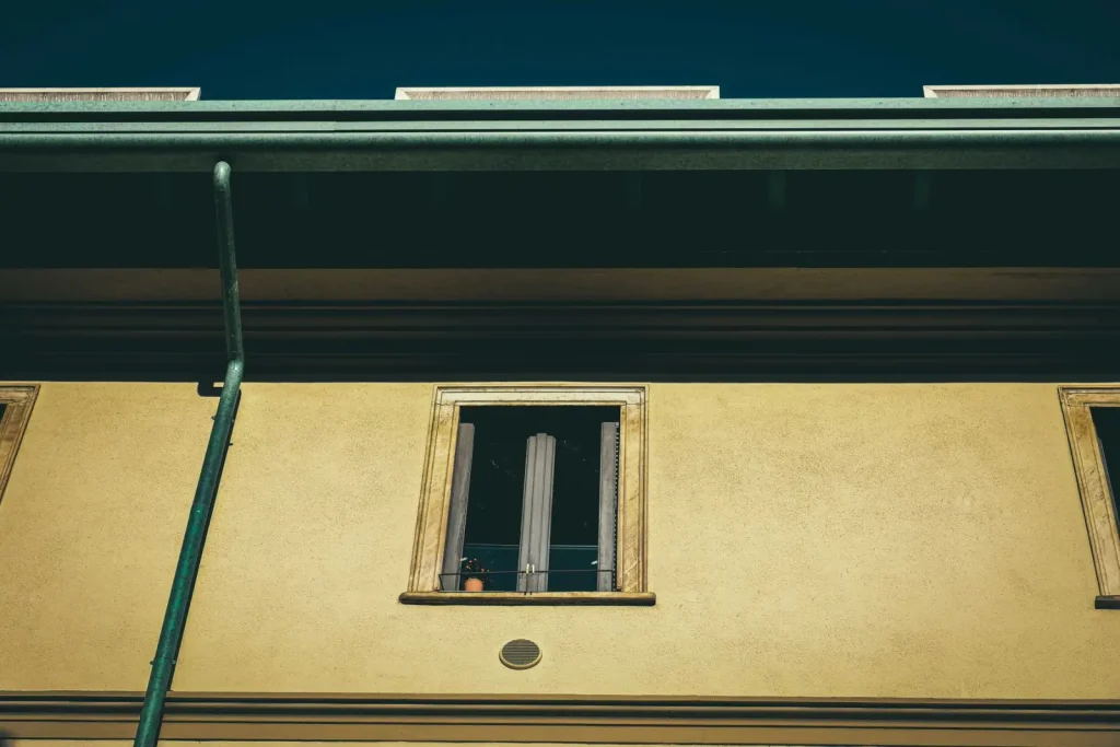 Aged dwelling exterior with windows and guttering