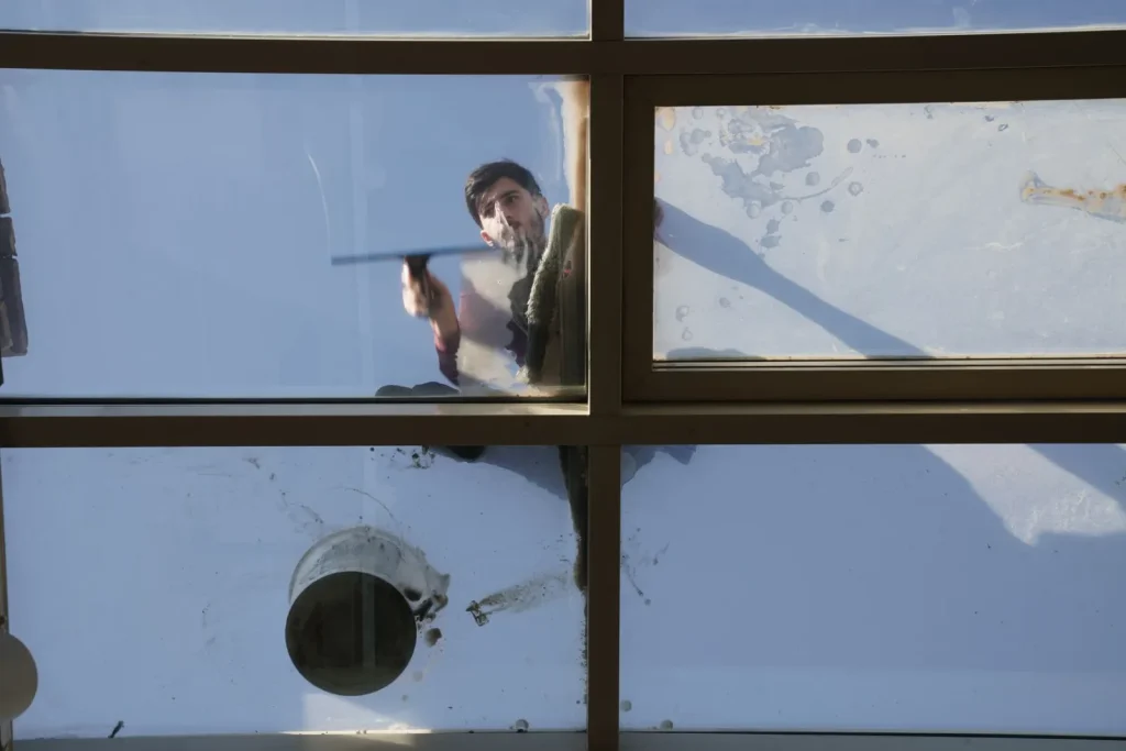 Cleaner washing an exterior glass roof