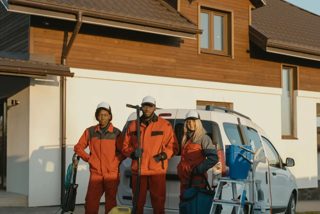 Exterior cleaning crew with equipment outside a modern home