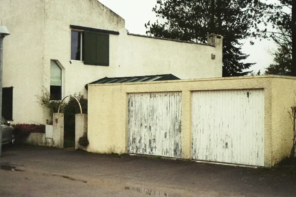 Older residential house with weathered garage doors