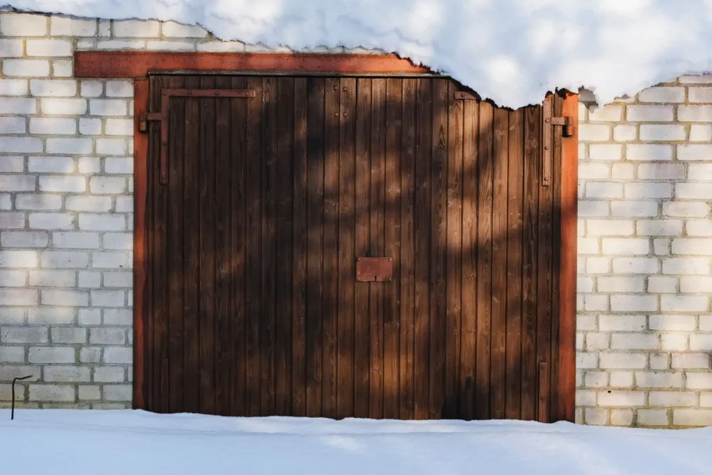 Wooden garage door framed by brick walls