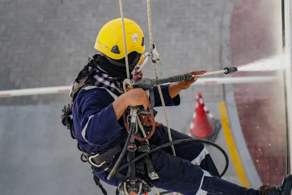 Worker cleaning a building exterior from height