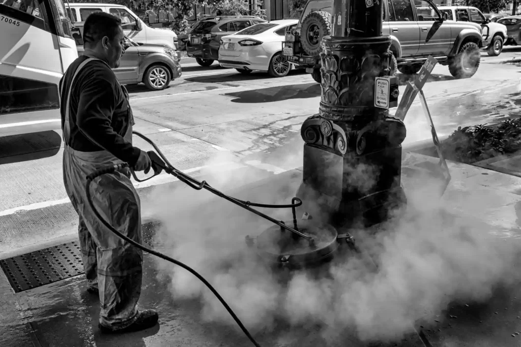 Worker cleaning a street fixture