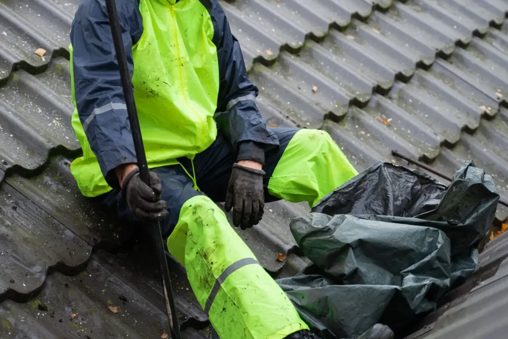 Worker in safety gear carrying out roof maintenance